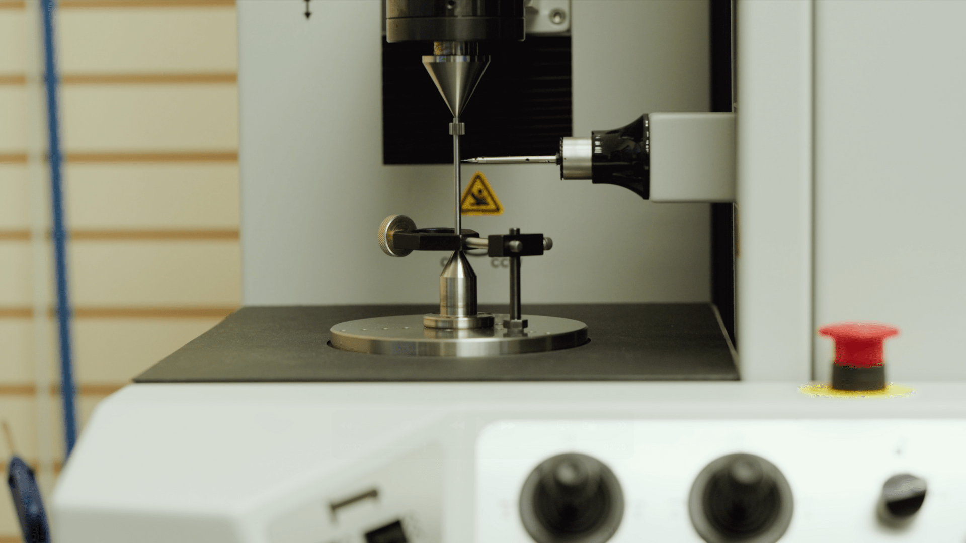 Close-up of a precision measurement probe inspecting a small machined metal component on a testing platform, illustrating quality control in medical machining.